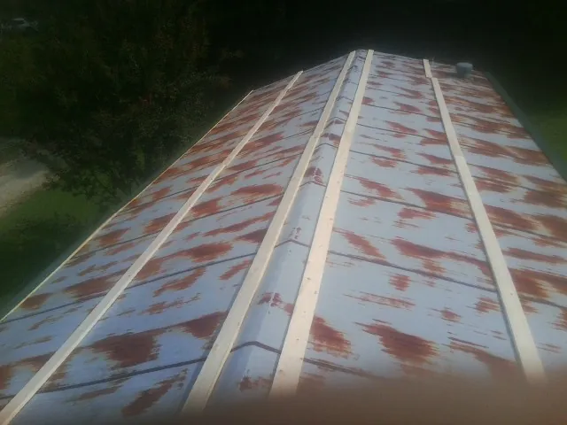Rusted metal roof panels with new wood purlins before replacement — Storm Damage Roof Repair in Dillon by Roofing Brothers